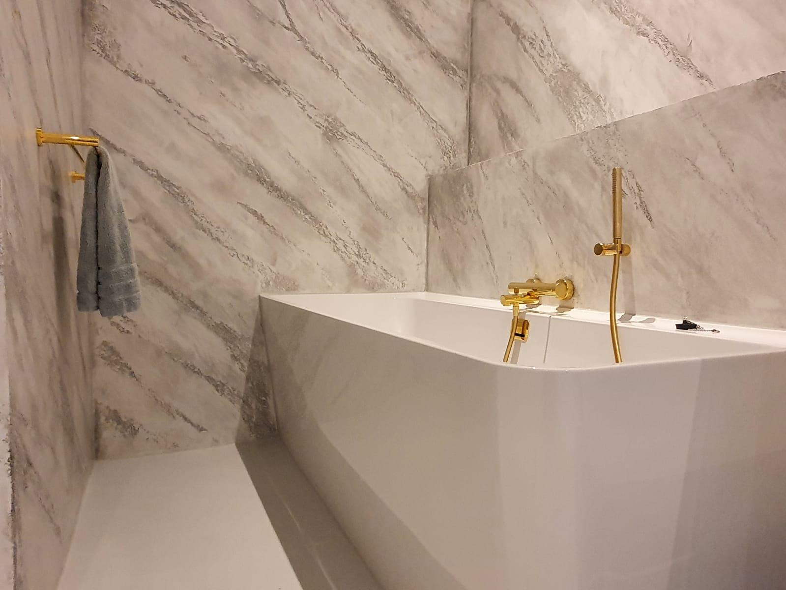 Complete badkamer gestuukt met gouden kranen